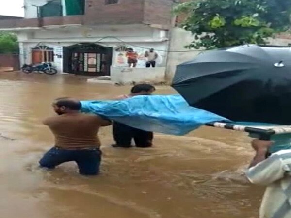 MP: Pregnant woman carried on cot through flooded streets MP: Pregnant woman carried on cot through flooded streets