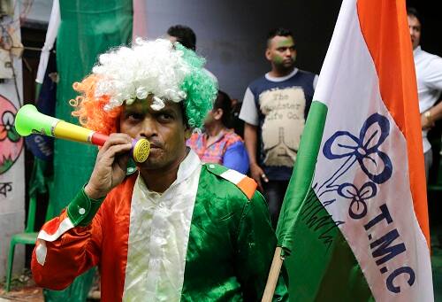 A supporter of All India Trinamool Congress party dressed in party colors celebrate after winning the West Bengal state assembly election, in Kolkata, India, Thursday, May 19, 2016. (AP Photo/ Bikas Das)