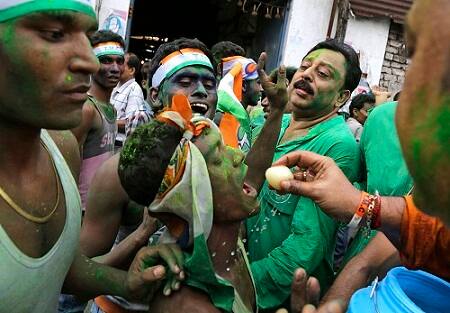 Supporters of All India Trinamool Congress party celebrate after winning the West Bengal state assembly election by dancing and offering sweets to each other in Kolkata. (AP Photo/ Bikas Das)