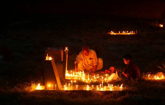 A Kashmiri Shiite Muslim lights candles at the grave of his relative to mark Shab-e- Barat on the outskirts of Srinagar on Sunday, May 22, 2016.