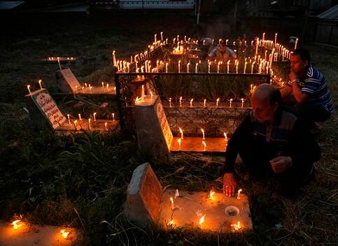 Hand of a Kashmiri Shiite Muslim is seen touching the grave of his relative as he offer prayers to mark Shab-e- Barat on the outskirts of Srinagar.