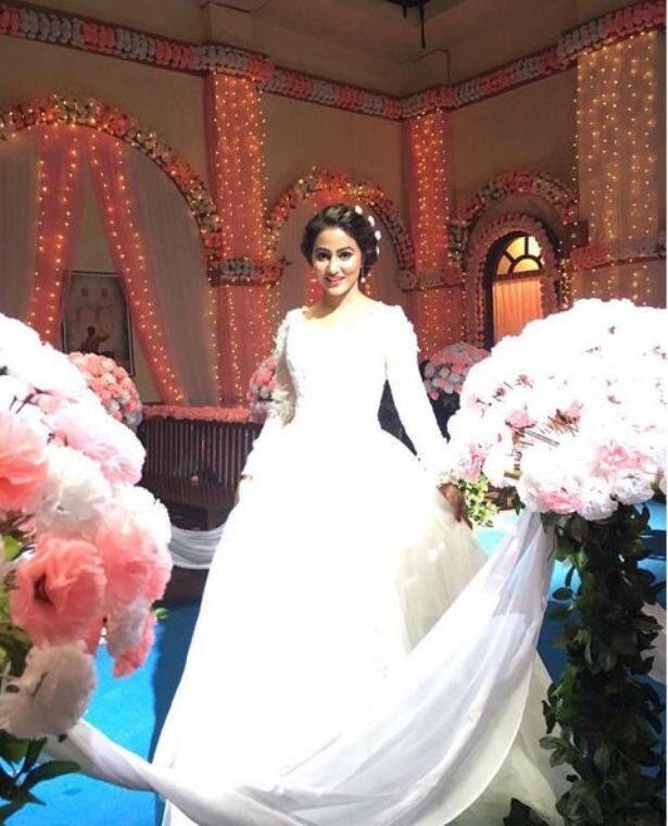 She looks stunning in the gown with her hair decorated with flowers!