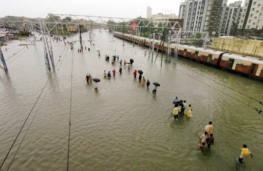 Commuters walk through the waterlogged Mahim-Wadala railway junction.