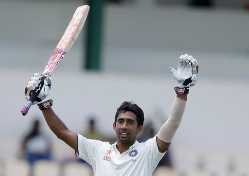 India's wicketkeeper Wriddhiman Saha celebrates after he scored a century against West Indies during day two of their third cricket Test match at the Daren Sammy Cricket Ground in Gros Islet, St. Lucia, on Wednesday. (AP)