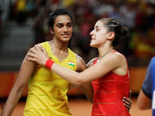 Spain's Carolina Marin, right, embraces India's V. Sindhu Pusarla, left, after Marin won the women's badminton singles gold medal match at the 2016 Summer Olympics in Rio de Janeiro, Brazil, Friday, Aug. 19, 2016. (AP Photo/Kin Cheung)