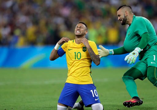 Brazil's Neymar cries as he kneels down to celebrate with teammate goalkeeper Weverton after scoring the decisive penalty kick during the final match of the men's Olympic football tournament between Brazil and Germany at the Maracana stadium in Rio de Janeiro, Brazil, Saturday Aug. 20, 2016. Brazil won the gold medal on  a penalty shootout. (AP Photo/Andre Penner)