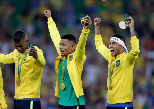Brazil's Neymar, right, and Gabriel Jesus, center, celebrate after receiving their gold medals after the final match of the men's Olympic football tournament between Brazil and Germany at the Maracana stadium in Rio de Janeiro, Brazil. Brazil won the gold medal on penalty shoot-out. (AP)