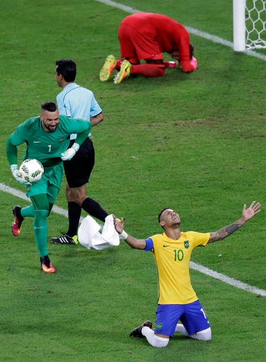 Brazil's Neymar celebrates with teammate goalkeeper Weverton, left, after scoring the decisive penalty kick during the final match of the men's Olympic football tournament between Brazil and Germany at the Maracana stadium in Rio de Janeiro, Brazil, Saturday Aug. 20, 2016. Brazil won the gold medal on a penalty shootout. (AP Photo/Andre Penner)