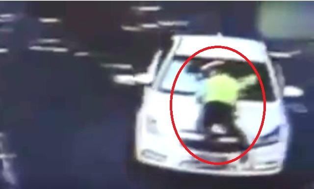 Watch: Police officer hangs onto windshield of moving car in an attempt to stop driver Watch: Police officer hangs onto windshield of moving car in an attempt to stop driver