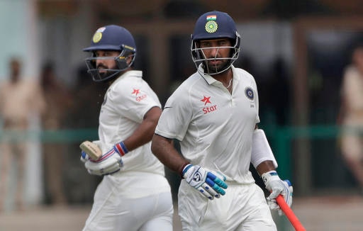 India's Murali Vijay, left and Cheteshwar Pujara, run between wickets against New Zealand during their first cricket test in Kanpur, India (AP Photo)