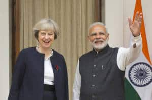 Indian prime Minister Narendra Modi, right, waves to media as his British counterpart Theresa May watches before their meeting in New Delhi, India, Monday, Nov. 7, 2016. Modi and May have begun wide-ranging talks aimed at deepening ties between their two countries and boosting trade and investment as the U.K. plans to leave the European Union. May arrived in New Delhi late Sunday on her first bilateral visit overseas since she became prime minister in July. (AP Photo/Manish Swarup)