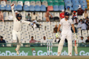 India's wicket-keeper, Parthiv Patel, left, celebrates after taking the catch of England's Jonny Bairstow, on the third day of their third cricket test match in Mohali, India, Monday, Nov. 28, 2016. (AP Photo/Altaf Qadri)