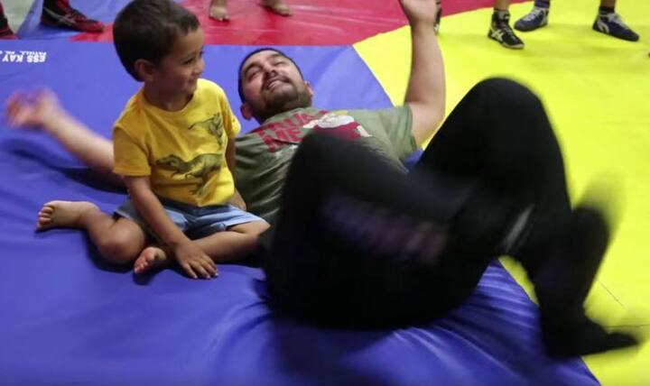 At the start, you will see the little boy stayed with daddy when he was busy practicing during his wrestling training process. 