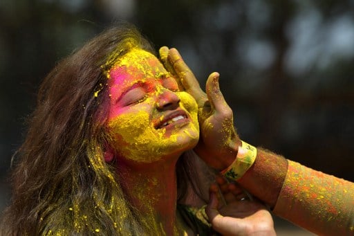 Indian revellers play with colours during celebrations for the Holi festival in Hyderabad on March 13, 2017. Holi marks the welcoming of spring and is a celebration of the triumph of good over evil, with people chasing each other and playfully splashing colorful paint, powder and water on each other. / AFP PHOTO / NOAH SEELAM