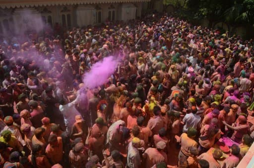 Indian Hindu devotees take part in celebrations for the Holi festival at a Temple in Siliguri on March 13, 2017. Holi marks the welcoming of spring and is a celebration of the triumph of good over evil, with people chasing each other and playfully splashing colorful paint, powder and water on each other. / AFP PHOTO / DIPTENDU DUTTA