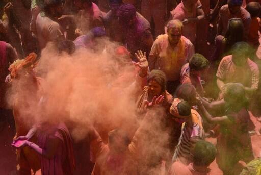 Indian Hindu devotees take part in celebrations for the Holi festival at a Temple in Siliguri on March 13, 2017. Holi marks the welcoming of spring and is a celebration of the triumph of good over evil, with people chasing each other and playfully splashing colorful paint, powder and water on each other. / AFP PHOTO / DIPTENDU DUTTA