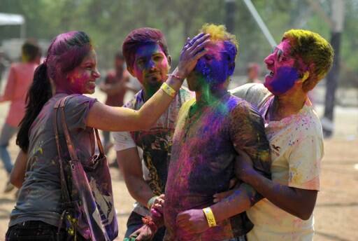 Indian revellers play with colours during celebrations for the Holi festival in Hyderabad on March 13, 2017. Holi marks the welcoming of spring and is a celebration of the triumph of good over evil, with people chasing each other and playfully splashing colorful paint, powder and water on each other. / AFP PHOTO / NOAH SEELAM