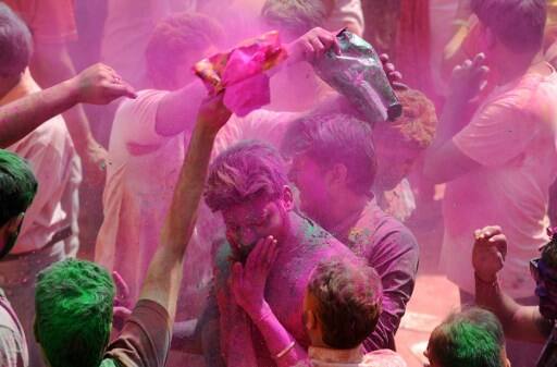 Indian Hindu devotees take part in celebrations for the Holi festival at a Temple in Siliguri on March 13, 2017. Holi marks the welcoming of spring and is a celebration of the triumph of good over evil, with people chasing each other and playfully splashing colorful paint, powder and water on each other. / AFP PHOTO / DIPTENDU DUTTA