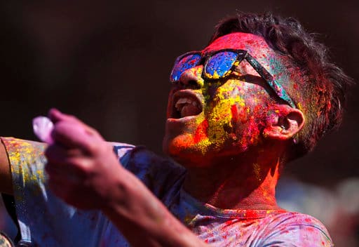 A Nepalese man with colored powder on face dances during Holi festivities at the Basantapur Durbar Square in Kathmandu, Nepal, Sunday, March 12, 2017. The Holi festival marks the advent of spring. (AP Photo/Niranjan Shrestha)