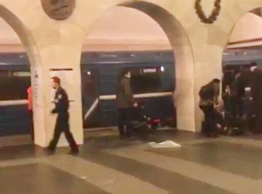 In this image taken from video footage filmed from a moving train on the opposite platform to where the blast occurred, people injured in blast. right, at St. Petersburg's Technological Institute metro station lay on ground, Russia, Monday, April 3, 2017. At least 10 people were killed Monday in an explosion on the subway in St. Petersburg, Russian news agencies reported. (@DARIIIIIINA via AP)