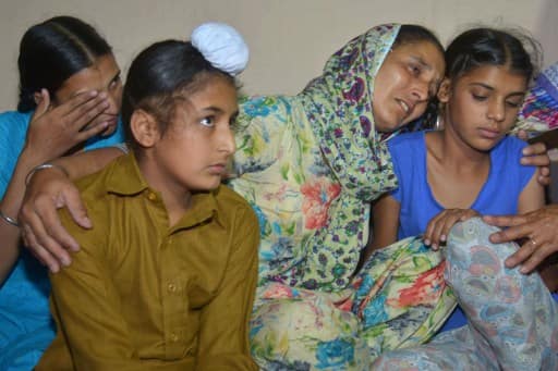 Wife of Indian army soldier Paramjeet Singh, Paramjeet Kaur (2nd R) cries with her daughters Simrandeep Kaur (rear L) and Khushdeep Kaur (R) and son Sahildeep Singh (L) at their residence in Vein Pein village, some 45 km from Amritsar, on / AFP PHOTO
