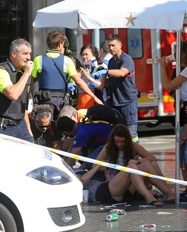 Injured people are treated in Barcelona, Spain, Thursday, Aug. 17, 2017 after a white van jumped the sidewalk in the historic Las Ramblas district, crashing into a summer crowd of residents and tourists and injuring several people, police said. (AP Photo/Oriol Duran)