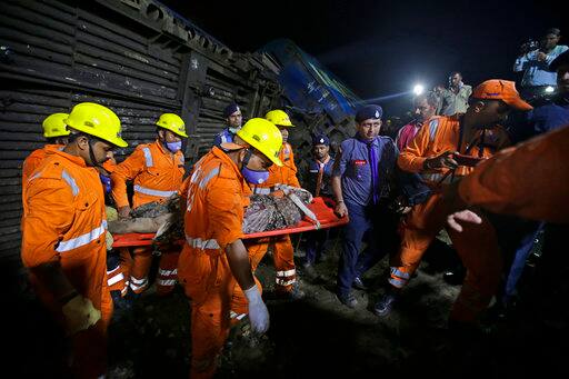 Rescuers carry the body of a victim recovered from upturned coaches of the Kalinga-Utkal Express after an accident near Khatauli, in the northern Indian state of Uttar Pradesh, India, Sunday, Aug. 20, 2017. Six coaches of a passenger train derailed in northern India on Saturday, killing more than 20 people and injuring dozens, officials said. (AP Photo/Altaf Qadri)