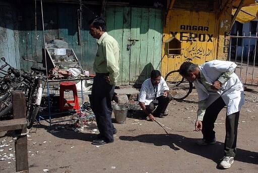 The investigating agencies had earlier allegedly attributed the blast to right-wing group Abhinav Bharat. (FILE PIC/AFP: Forensic experts search for clues at the blast site in Malegaon.) INFO/IANS