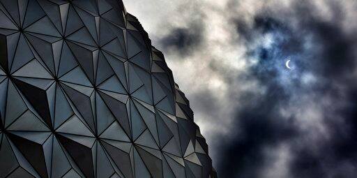 Rain clouds obscure the solar eclipse tracking over Spaceship Earth at Epcot at Walt Disney World in Lake Buena Vista, Fla., Monday, Aug. 21, 2017. The eclipse was partially blocked as it approached totality because of the weather in the area. (Joe Burbank/Orlando Sentinel via AP)