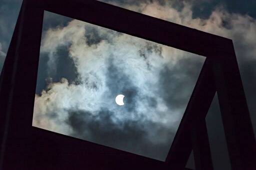 The beginning of the solar eclipse is framed in the Netherlands Carillon in Arlington, Va., Monday, Aug. 21, 2017. The carillon is a gift from the government of the Netherlands and sits across the Potomac River from Downtown Washington. (AP Photo/J. David Ake)