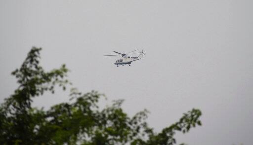A chopper believed to be transporting leader of Dera Sacha Sauda sect, who calls himself Saint Dr. Gurmeet Ram Rahim Singh Ji Insaan, flies over Rohtak, India, Friday, Aug. 25, 2017. Deadly riots have broken out in a north Indian town after a court convicted the guru of raping two of his followers. He was taken into custody and would be housed in a jailhouse in Rohtak in Haryana state until his Aug. 28 sentencing hearing, prosecutor H.P.S. Verma said. (AP Photo/Deepak Khanna)