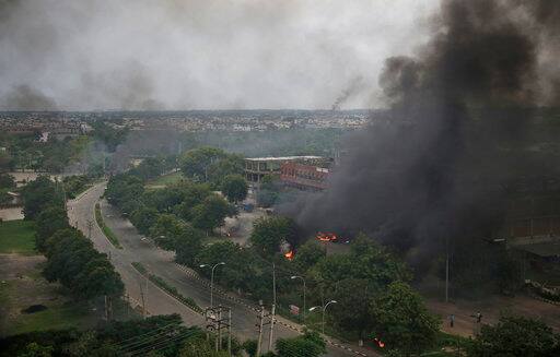 Smoke billows after supporters of the Dera Sacha Sauda sect set vehicles on fire near in Panchkula, India, Friday, Aug. 25, 2017. Deadly riots have broken out in a north Indian town after a court convicted a guru of raping two of his followers. Mobs also attacked journalists and set fire to government buildings and railway stations. (AP Photo/Altaf Qadri)