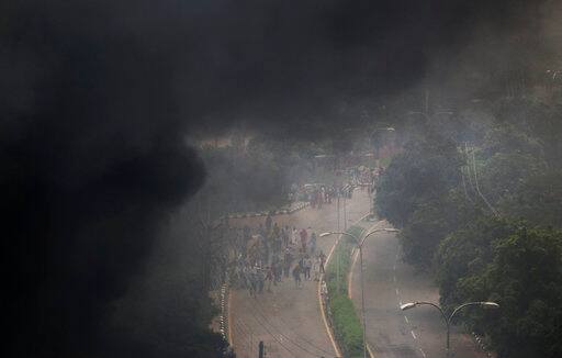 Smoke rises from vehicles set on fire by Dera Sacha Sauda sect members burn in the streets of in Panchkula, India, Friday, Aug. 25, 2017. Deadly riots have broken out in a north Indian town after a court convicted the sect's guru of raping two of his followers. Mobs also attacked journalists and set fire to government buildings and railway stations. (AP Photo/Altaf Qadri)