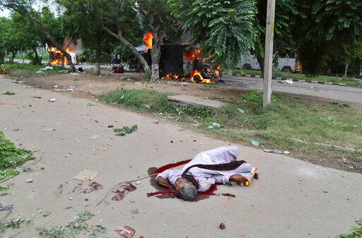 A man lies on a road in a pool of blood after Dera Sacha Sauda sect members went on a rampage near a court in Panchkula, India, Friday, Aug. 25, 2017. Deadly riots have broken out in the northern Indian town after a court convicted the sect's guru of raping two of his followers. Mobs also attacked journalists and set fire to government buildings and railway stations. (AP Photo/Kapil Sethi)