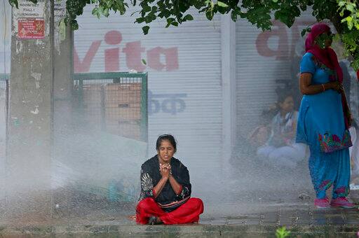 A Dera Sacha Sauda sect supporter braves water cannon used by Indian security forces to disperse violent supporters near a court in Panchkula, India, Friday, Aug. 25, 2017. Deadly riots have broken out in the north Indian town after a court convicted their guru, who calls himself Saint Dr. Gurmeet Ram Rahim Singh Ji Insaan, of raping two of his followers. Mobs also attacked journalists and set fire to government buildings and railway stations. (AP Photo/Altaf Qadri)