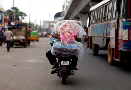 A devotee holds an idol of the elephant-headed Hindu God Ganesha on the back of a motorcycle during Ganesh Chaturthi festival celebrations in Hyderabad, India, Friday, Aug. 25, 2017. The idols of Ganesha are immersed in water bodies at the end of the ten-day festival. (AP Photo/Mahesh Kumar A.)