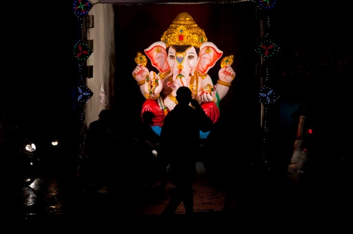 An Indian walks in front of an idol of elephant-headed Hindu god Ganesh on the second day of the Ganesh Chaturti festival in Hyderabad, Saturday, Aug. 26, 2017. The ten-day long Ganesh Chaturthi festival celebrates the birth of Ganesha. (AP Photo /Mahesh Kumar A.)