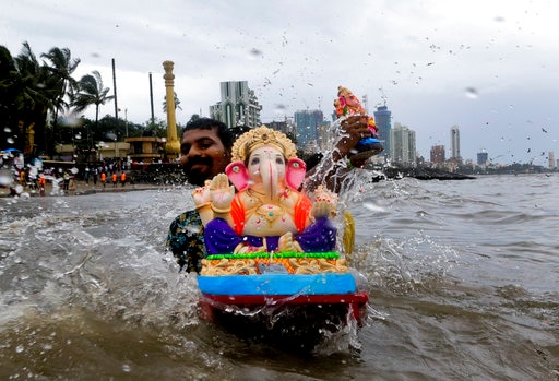 Hindu devotees carry Ganesha idols for immersion in the Arabian sea on the second day of Ganesh Chaturthi festival in Mumbai, India, Saturday, Aug. 26, 2017. The ten-day long festival is dedicated to the worship of elephant-headed Hindu god Ganesha. (AP Photo/Rajanish Kakade)