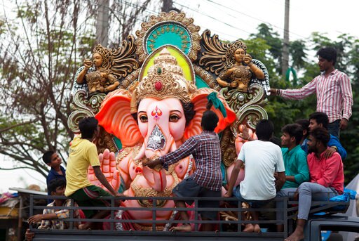 Devotees transport a giant idol of the elephant-headed Hindu God Ganesha for worship during Ganesh Chaturthi festival celebrations in Hyderabad, India, Friday, Aug. 25, 2017. The idol will be immersed in a water body at the end of the ten-day festival. (AP Photo/Mahesh Kumar A.)