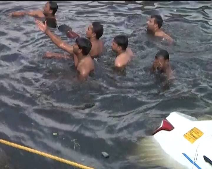 A car was pushed into the Kondli canal flowing next to the garbage dump. A two-wheeler also got submerged due to the impact that came falling below.
