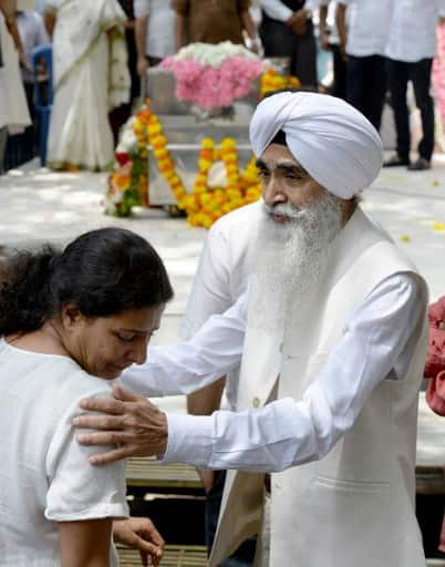 Family friend Chiranjeevi Singh (R) consoles Kavita Lankesh, sister of Indian journalist Gauri Lankesh, as relatives, friends and the public paid their respects by her body through the industry./AFP 
