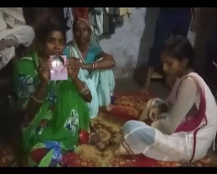 Rahul's mother holding his picture after he went missing for 17 days