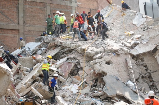A powerful earthquake shook central Mexico on Tuesday, collapsing buildings in plumes of dust and killing at least 149 people. Thousands fled into the streets in panic, and many stayed to help rescue those trapped. PIC: First responders work on removing the rubble of a collapsed building looking for survivors trapped underneath. (AP)