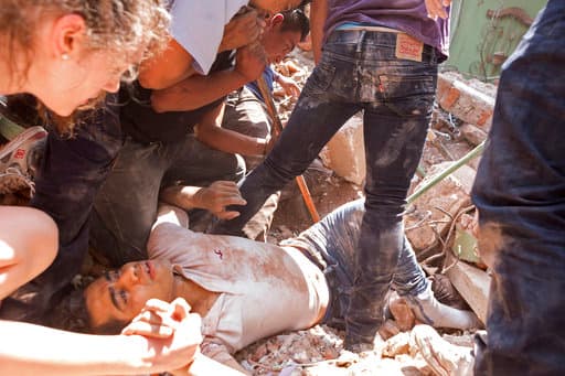 RETRANSMITTING FOR HIGHER QUALITY FILE - A man is rescued from a collapsed building in the Condesa neighborhood after an earthquake struck Mexico City, Tuesday, Sept. 19, 2017. The 7.1 earthquake stunned central Mexico, killing more than 100 people. (AP Photo/Pablo Ramos)