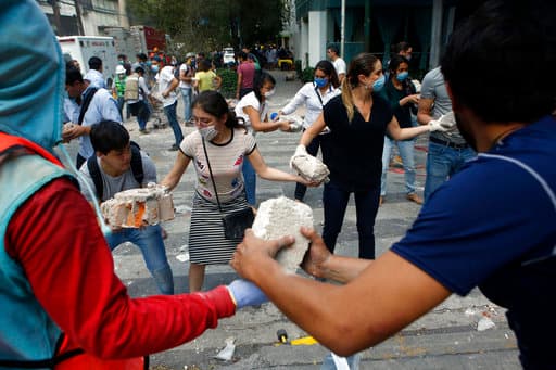 Volunteers pick up the rubble from a building that collapsed during an earthquake in the Condesa neighborhood of Mexico City, Tuesday, Sept. 19, 2017. A powerful earthquake jolted central Mexico on Tuesday, causing buildings to sway sickeningly in the capital on the anniversary of a 1985 quake that did major damage. (AP Photo/Rebecca Blackwell)