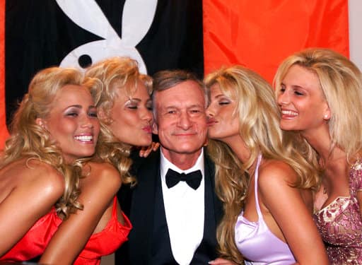 FILE - In this May 14, 1999 file photo, Playboy founder and editor in chief Hugh Hefner receives kisses from Playboy playmates during the 52nd Cannes Film Festival in Cannes, France. PIC/AP.