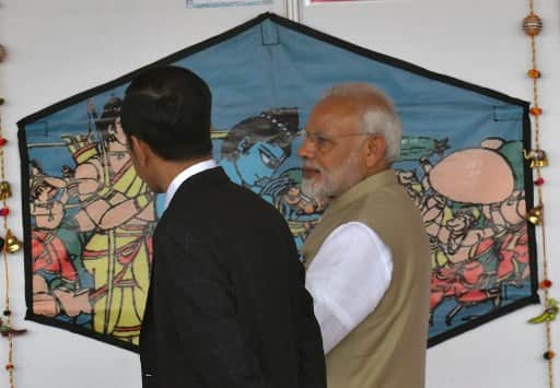 India's Prime Minister Narendra Modi shows Indonesia's President Joko Widodo (L) a kite on display at the India-Indonesia kite exhibition at the National Monument in Jakarta on May 30, 2018. / AFP PHOTO / Goh Chai Hin