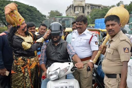 The actor, who stopped motorists and reminded them of the importance of sticking to road rules, was Veeresh, a theatre artiste performing Hindu mythology-based dramas. After intercepting mostly young motorists, Yama waved his mace in the air, warning them that he would not spare them./ AFP PHOTO / MANJUNATH KIRAN