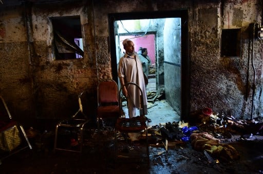 A Pakistani Awami National Party (ANP) supporter stands at the site after a suicide bombing at an election rally in Peshawar. AFP PHOTO 
