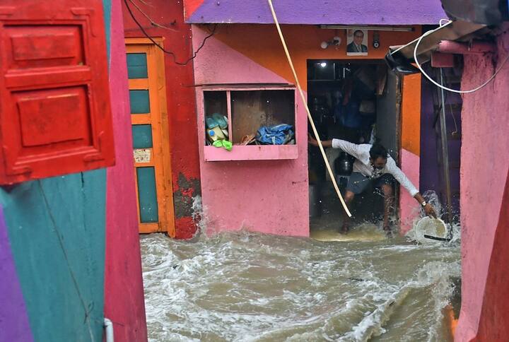  A high tide wave hits a man standing outside his house as the seawater enters the shanty town near the shore, at Bandra in Mumbai. PTI Photo